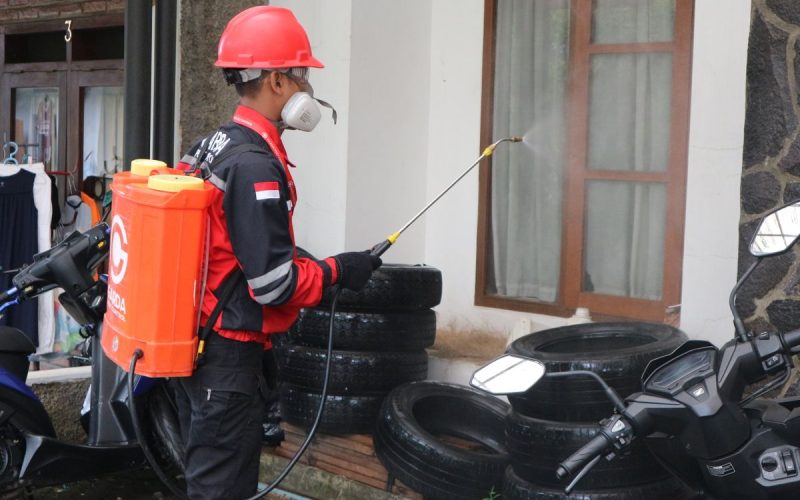 Pest control technician spraying the exterior of a building